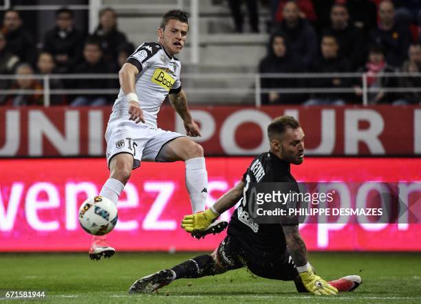 Angers' French midfielder Pierrick Capelle vies with Dijon's French goalkeeper Baptiste Reynet during the French L1 football match between Dijon FCO...