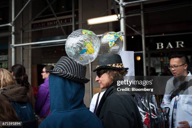 Demonstrators wear inflatable globes on hats as they attend the March for Science rally on Earth Day in New York, U.S., on Saturday, April 22, 2017....