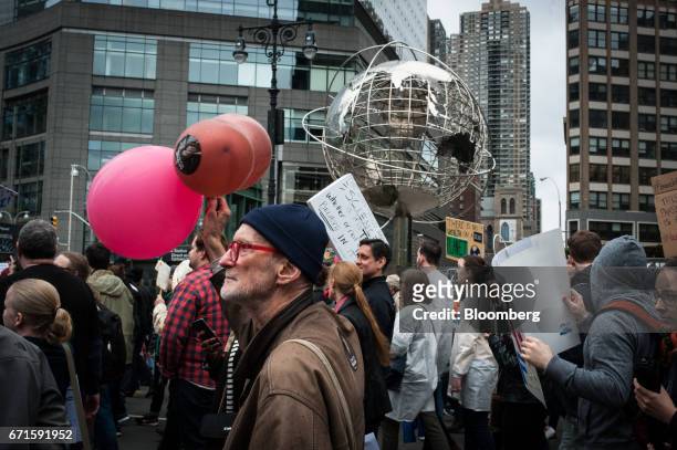 Demonstrators carry signs outside of the Trump International Hotel and Tower during the March for Science rally on Earth Day in New York, U.S., on...
