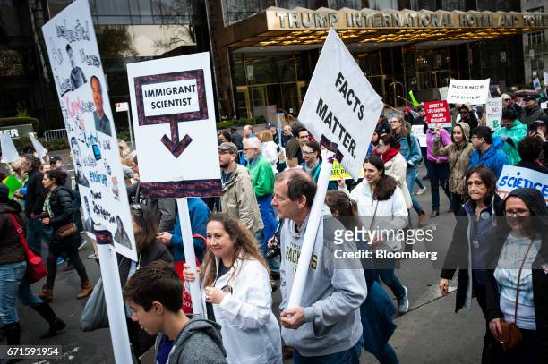 Demonstrators carry signs outside of the Trump International Hotel and Tower during the March for Science rally on Earth Day in New York, U.S., on...