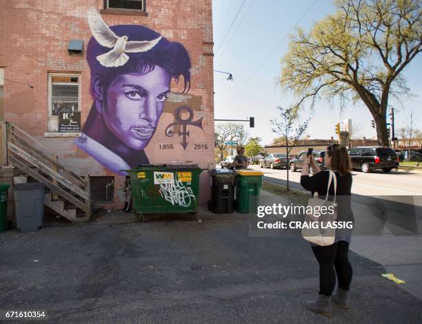 Erin Monfort of Des Moines, Iowa, photographs a Prince mural on the back of a store in the Uptown neighborhood of Minneapolis, Minnesota, April 22 on...