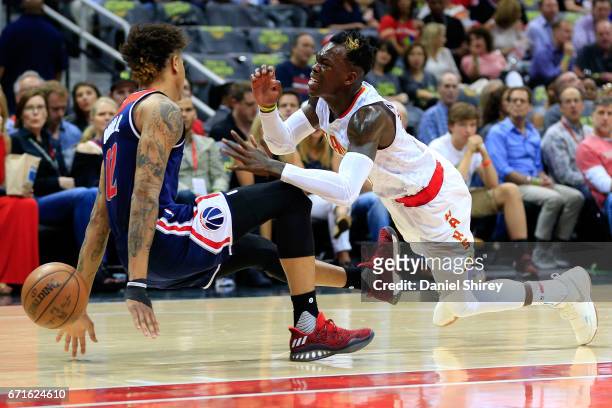 Dennis Schroder of the Atlanta Hawks is fouled by Kelly Oubre Jr. #12 of the Washington Wizards during the first quarter in Game Three of the Eastern...