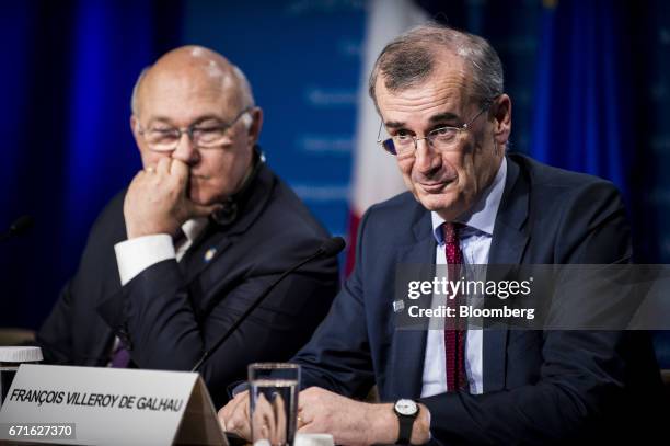 Francois Villeroy de Galhau, governor of the Bank of France, right, and Michel Sapin, France's finance minister, listen during a press conference at...