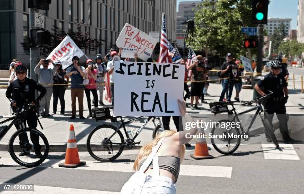 Woman is seen demonstrating in front of a small pro-Trump counter demonstration as scientists and supporters participate in a March for Science on...