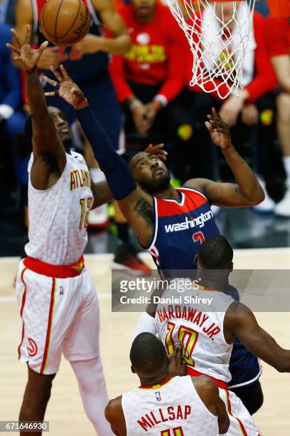 John Wall of the Washington Wizards shoots a basket over Tim Hardaway Jr. #10 of the Atlanta Hawks during the third quarter in Game Three of the...