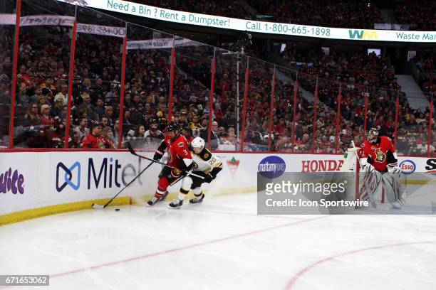 Ottawa Senators Defenceman Marc Methot moves the puck around the goal and trying to keep Boston Bruins Center Riley Nash off the puck in the third...