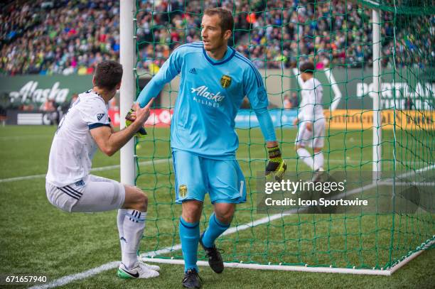 Portland Timbers goal keeper Jeff Attinella helps Vancouver Whitecaps midfielder Andrew Jacobson during the Portland Timbers home victory 2-1 against...