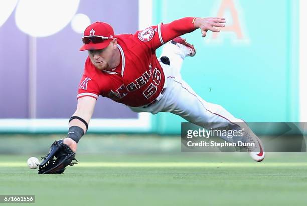 Right fielder Kole Calhoun of the Los Angeles Angels of Anaheim dives but can't reach a single hit by Kendrys Morales of the Toronto Blue Jays in the...