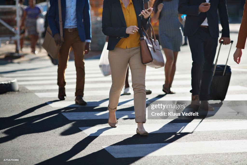 Business people walking on pedestrian crossing