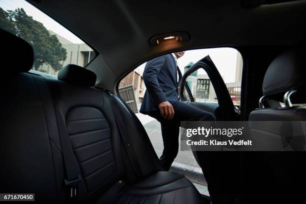 businessman getting into backseat of exclusive cab - entrando fotografías e imágenes de stock