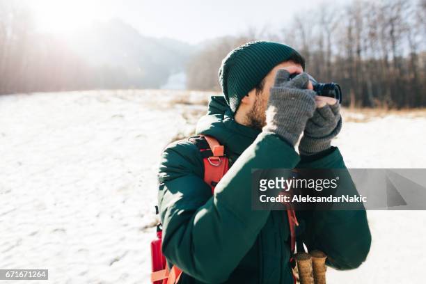 junge wanderer fotografieren winterlandschaft - staff photographer stock-fotos und bilder
