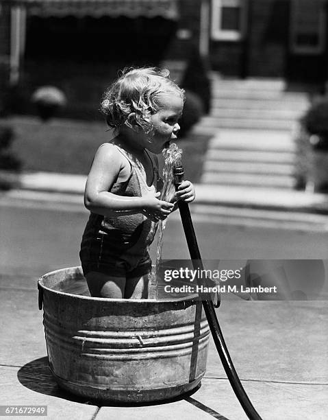 Baby Boy In Washtub Holding Hose.