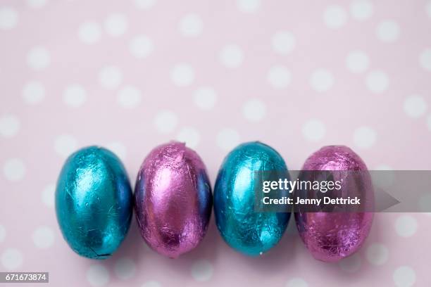 small easter eggs in a row - easter chocolate stock pictures, royalty-free photos & images