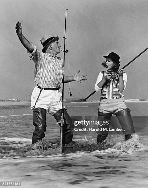 Senior Man And Woman Talking While Fishing On Beach.