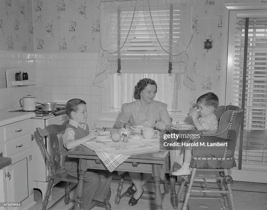  Mother And Children Having Breakfast In Kitchen