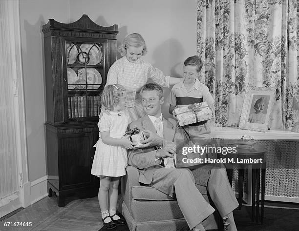 Son And Daughter Giving Gift To Father.