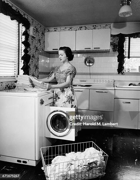 Woman Folding Clothes On Washing Machine .