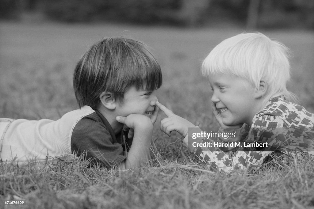  Boys And Girl Lying On Front And Looking Face To Face