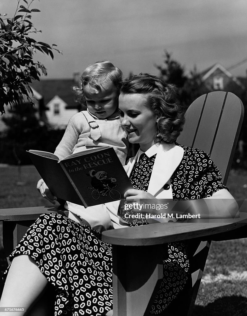  Mother And Daughter Sitting On Chair Reading Book