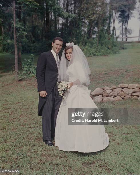 Portrait Of Bride And Groom Holding Bouquet .