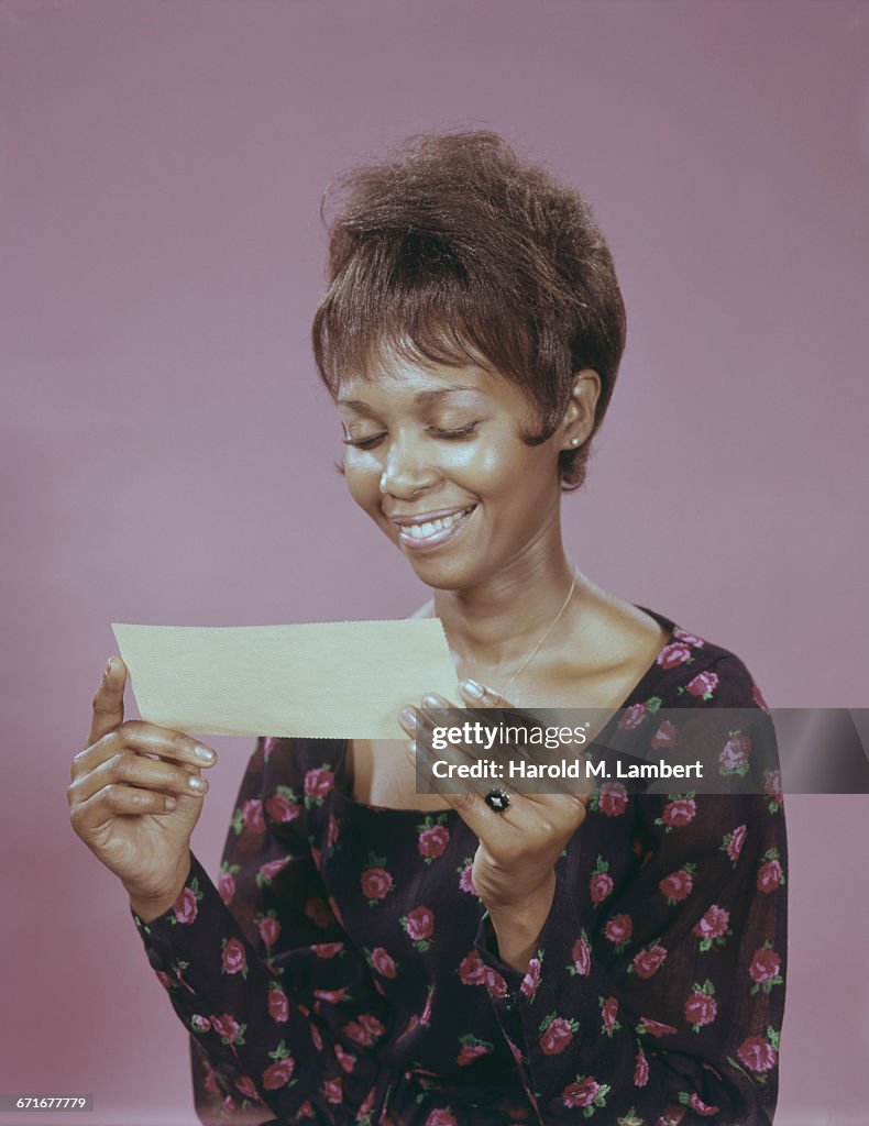 Woman Holding Check And Smiling 
