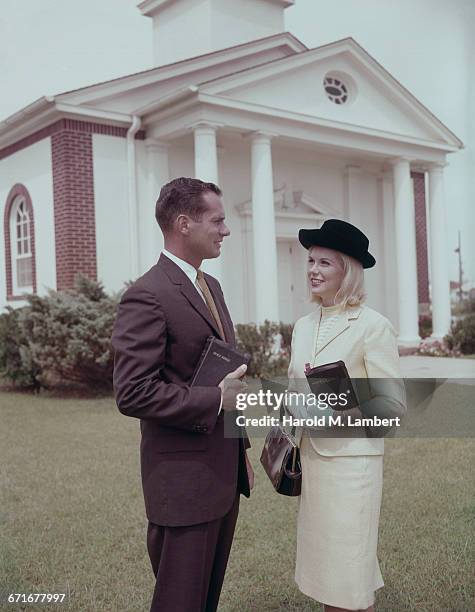 Couple Talking With Each Other Each Carrying Bible .