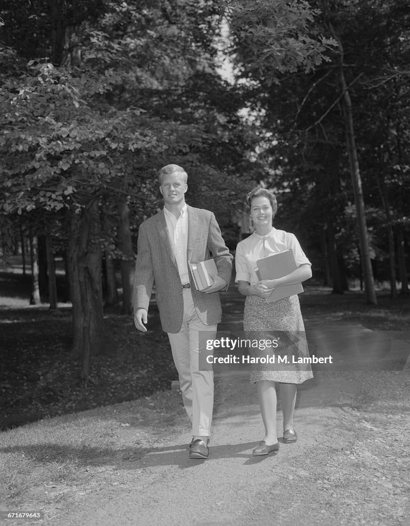  Young Man And Woman Walking With Book