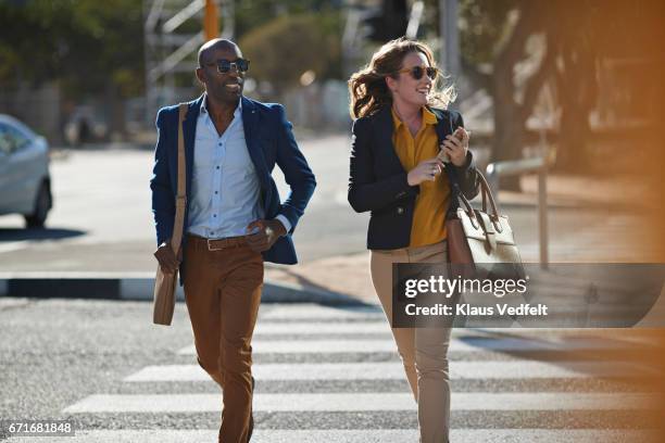 businesspeople running in pedestrian crossing with phones and bags - schwarze handtasche stock-fotos und bilder