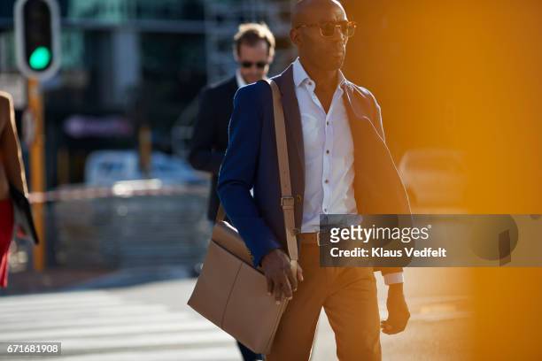 businesspeople walking in pedestrian crossing with phones and bags - man wearing cap photos et images de collection
