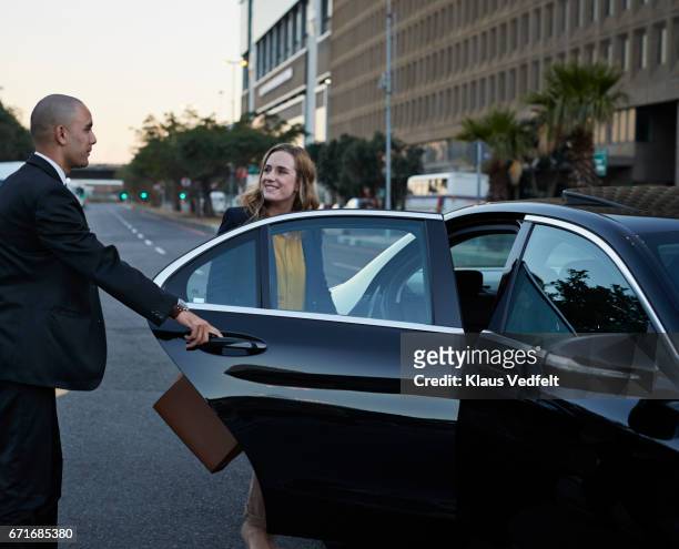 driver assisting businessman into cab - chauffeur 個照片及圖片檔