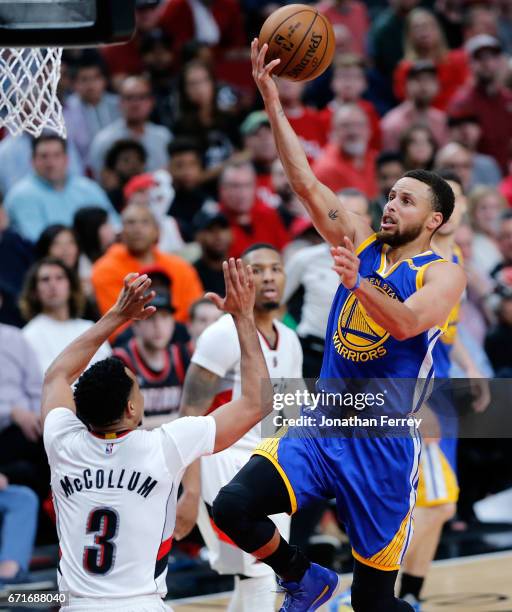 Stephen Curry of the Golden State Warriors lays up the ball over CJ McCollum the Portland Trail Blazers during Game Three of the Western Conference...