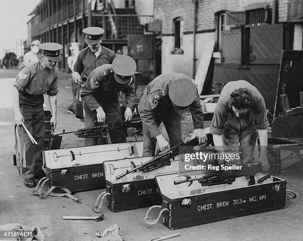 NCOs of the automatic weapons section of The Royal Scots Greys pack their Royal Small Arms Factory Bren .303 light machine guns ready for despatch to...