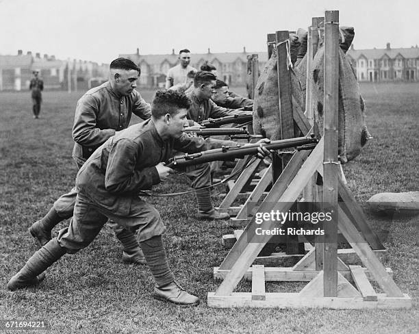 Soldiers from the Welch Regiment undertake bayonet thrust practice against straw filled dummies using the Short Magazine LeeEnfield Mk III .303 bolt...