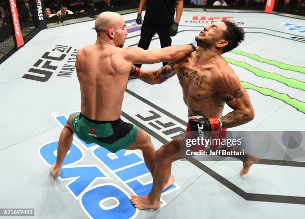 Artem Lobov of Russia punches Cub Swanson in their featherweight bout during the UFC Fight Night event at Bridgestone Arena on April 22, 2017 in...