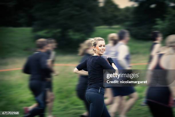 young woman running in race - nicolamargaret stock pictures, royalty-free photos & images