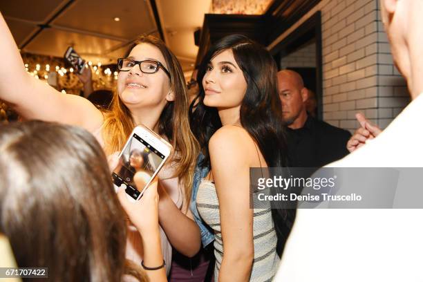 Kylie Jenner poses for a photo with a fan at Sugar Factory American Brasserie at the Fashion Show mall on April 22, 2017 in Las Vegas, Nevada.