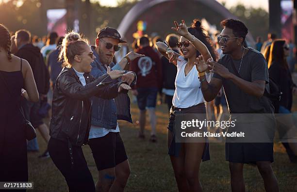 friends dancing together at big festival - festival field foto e immagini stock