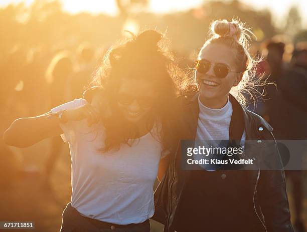 friends laughing together at big festival - vriendin stockfoto's en -beelden