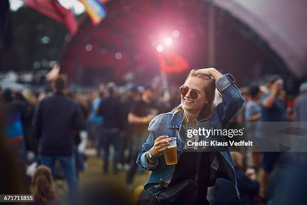 woman holding beer and laughing at concert - disposable cup stock pictures, royalty-free photos & images