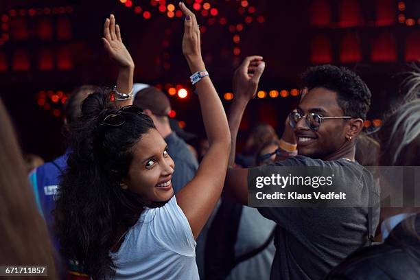 woman smiling to camera at concert - regarder par dessus son épaule photos et images de collection