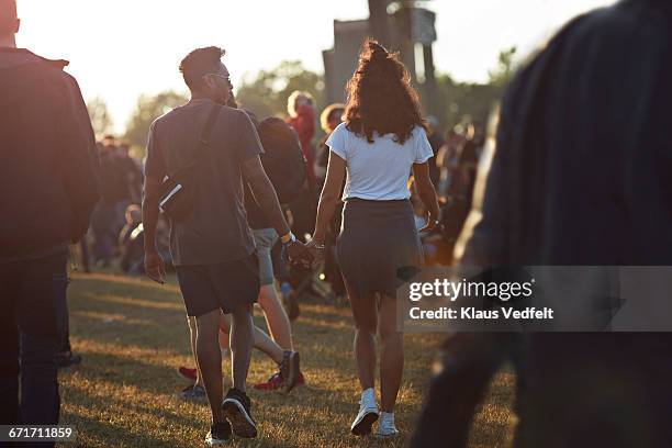 couple holding hands at big festival - music festival field stock pictures, royalty-free photos & images