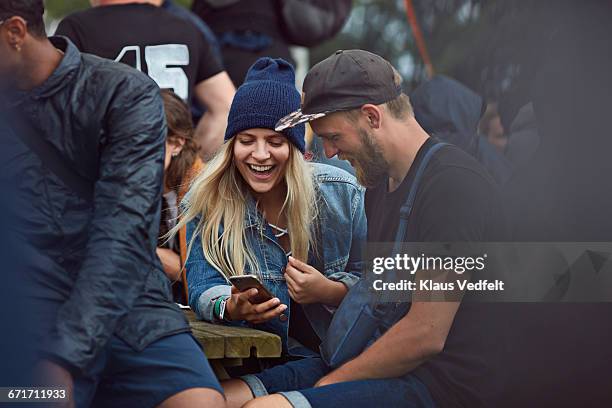 couple checking phone at festival - denmark people happy stock-fotos und bilder