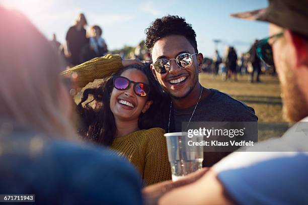friends laughing at big festival - couple concert photos et images de collection