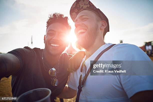 friends making selfie at big festival concert - lens flare portrait guy stock-fotos und bilder