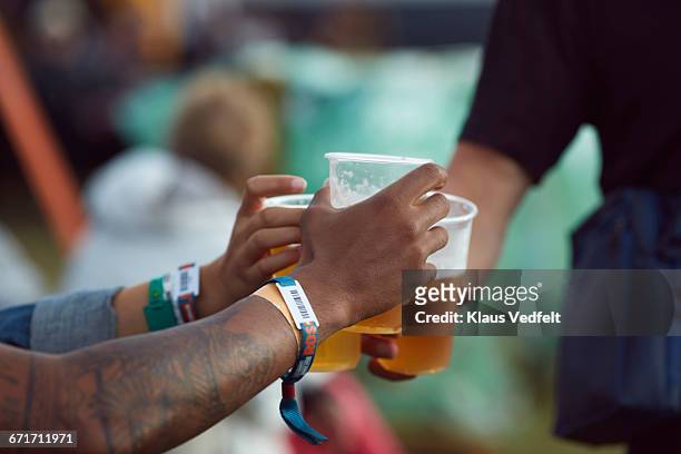 close-up uf hands toasting in beer, at festival - bracelet festival ストックフォトと画像