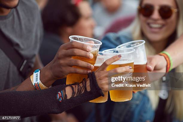 close-up uf hands toasting in beer, at festival - alkoholisches getränk stock-fotos und bilder