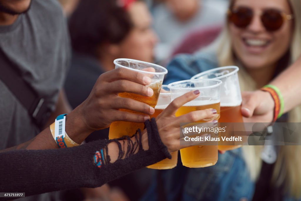 Close-up uf hands toasting in beer, at festival