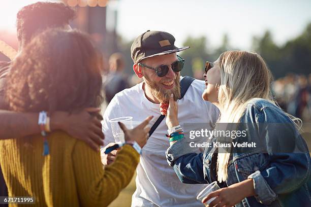 friends laughing together at concert - veralbern stock-fotos und bilder