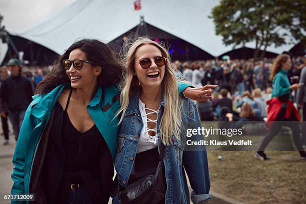 girlfriends laughing together at outside festival - festival field foto e immagini stock