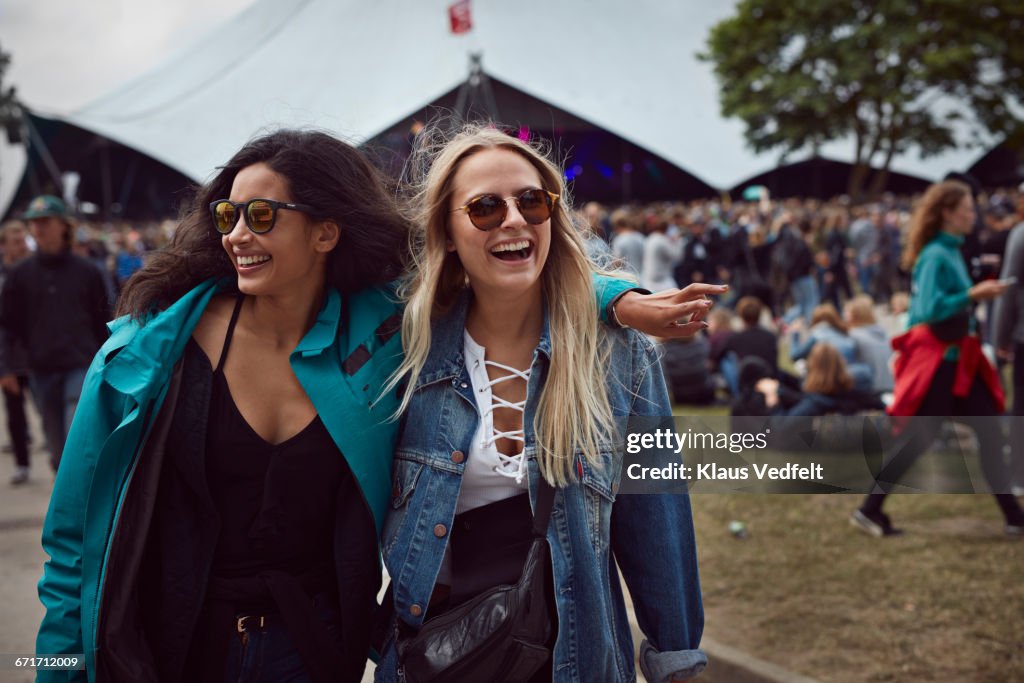 Girlfriends laughing together at outside festival